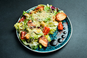Caesar salad with chicken. Restaurant menu. On a dark background, close-up.