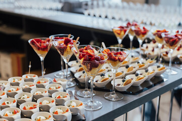 Strawberries and ananas in glasses. Catering on wedding. Sweet table with fruit and desserts, wedding catering. Fruit bar on party.