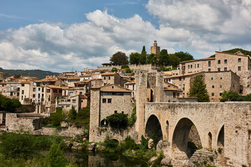 Fototapeta na wymiar The Besalú bridge is a Romanesque bridge with arches and defensive towers built in the Middle Ages. Girona. Catalonia. Spain