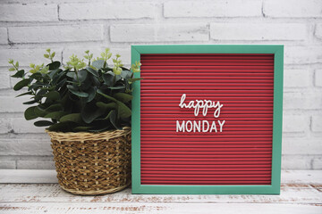 Hello Monday text on Letter Board artficial plant decoration on wooden background