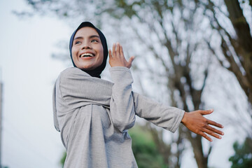 asian woman doing gymnastics and exercising outdoors excitedly