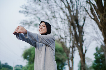 asian woman doing gymnastics and exercising outdoors excitedly