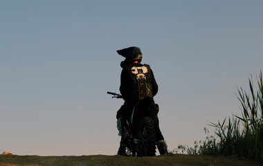 FMX rider performs dangerous stunts at sunset. Motocross.