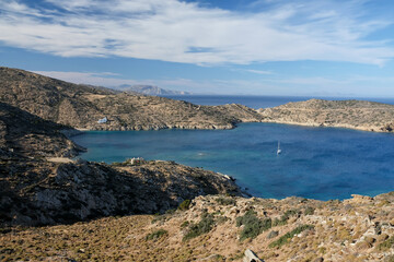 Fototapeta na wymiar Panoramic view of the beautiful Tris klisies beach and a sailboat in Ios Greece