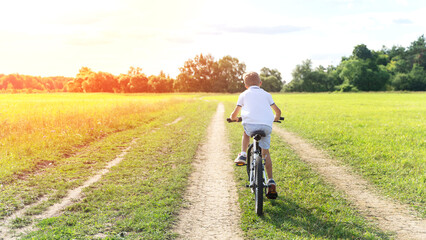 a boy rides a bicycle in nature