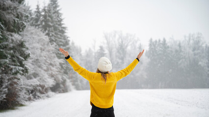 Woman enjoying life standing in white snowy winter nature - 614142692