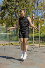 Athletic lebanese man in sportswear skipping rope. Young middle eastern arabian guy doing jumping...
