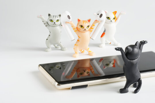 Funny toy cats advertise white wireless tws headphones next to mobile phones. copyspace. Photo.