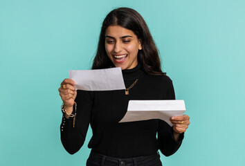 Pretty indian woman open envelope take out letter reads it feel happy. Hindu girl career growth...