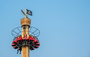 The attraction is a free fall tower against the sky.
