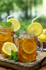 Ice tea in two glass jars with lemon and mint