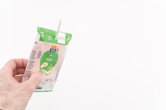 immagine editoriale illustrativa primo piano di mano che regge contenitore vuoto da smaltire per bibite in materiali riciclabili su superficie bianca