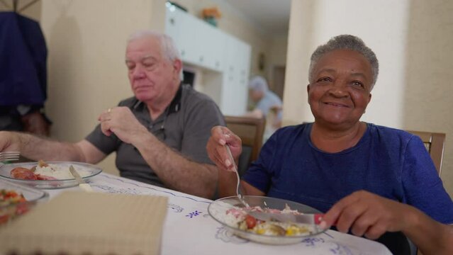 Close-Up Of African American Elderly Woman And Caucasian Male Friend At Lunch Reunion Of Senior Group