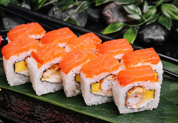 Set of salmon sushi rolls on stone plate