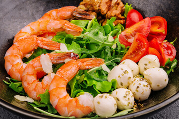 Salad with fresh arugula leaves, mozzarella cheese and shrimps