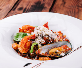 black spaghetti with seafood on white plate