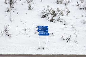 View of a roadsign by the road with directions to Cortina d'Ampezzo, Brunico and Dobbiaco, in a...