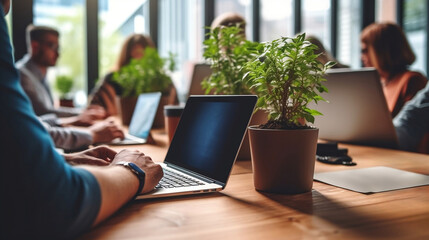 A group of people brainstorming in an office, sitting on chairs with laptops.