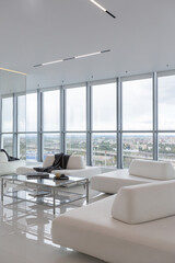 a white and very bright luxury fashionable apartment on a high floor with a free layout, a living room with expensive furniture and panoramic glazing