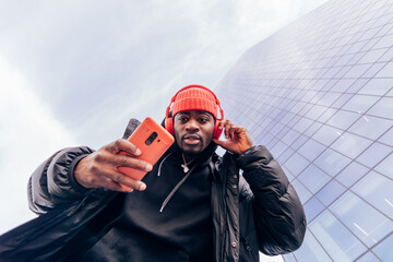 cool street style hypebeast hip hop rapper influencer recording music video using cell phone - obrazy, fototapety, plakaty
