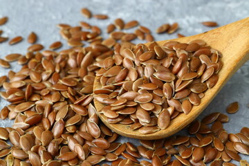 Flax seeds. Flaxseed powder in a wooden spoon. Standing on a Wooden background.