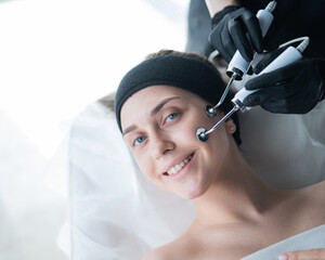 Young caucasian woman on microcurrent therapy procedure. Beautician's office.