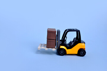 caminhão veículo empilhadeira de materiais de construção de brinquedo em fundo azul com espaço pra texto 