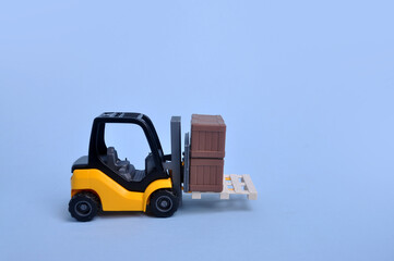 caminhão veículo empilhadeira de materiais de construção de brinquedo em fundo azul com espaço pra texto 