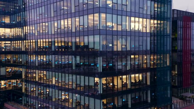 Aerial View of the Windows of a Skyscraper Where People Work in an Office Building in the Financial Center of the City at Night. Gdansk, Poland. Facade of night skyscraper windows Corporate offices