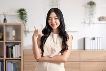 Beautiful young Asian woman showing thumbs up good gesture smile with positive emotional at home....