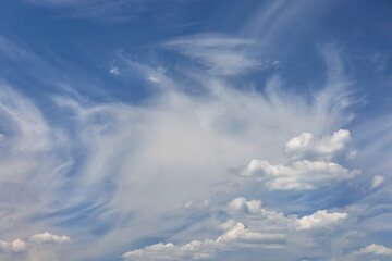 Blue sky background with haze and white clouds.