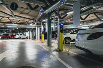 Electric cars are charged from the charging station in the indoor parking of the shopping center.