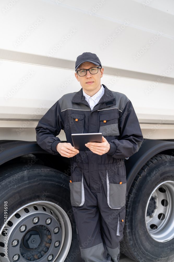 Poster manager with a digital tablet next to garbage truck..
