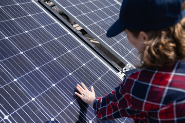 Woman with digital tablet touching solar panel.