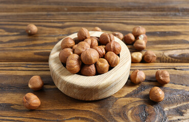 A bowl full of hazelnuts on a wooden table