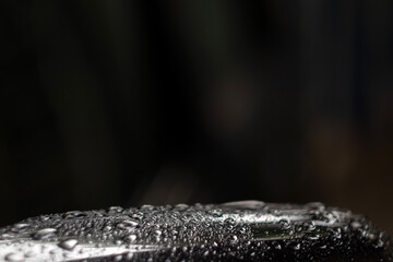 Water droplets on the surface in green color with nature light after the rain. Selective focus.