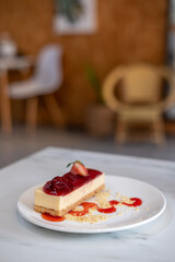 A piece of Strawberry cheesecake served on plate with sauce and crumble