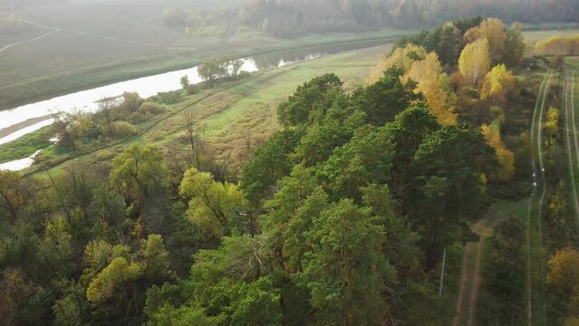 luftaufnahmen einer bunten Herbstlandschaft im Licht eines fr&uuml;hen Morgens mit Nebel am Flussbett. 4К