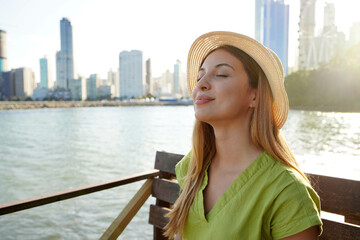 Close-up of beautiful young stylish woman enjoying Balneario Camboriu city feelings. Travel in...