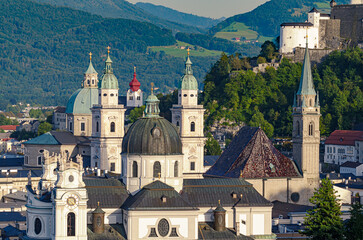 Obraz premium Salzburg, city in Austria, view at the old town and historic centre, with Collegiate Church, Franciscan Church and Salzburg Cathedral. In the distance a part of the medieval Hohensalzburg Fortress.