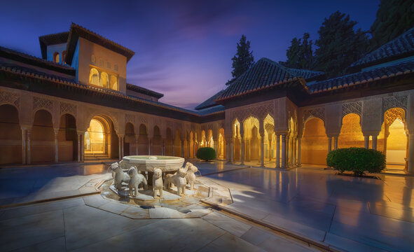 Illuminated Court of the Lions (Patio de los Leones) with fountain at Nasrid Palaces of Alhambra at night - Granada, Andalusia, Spain