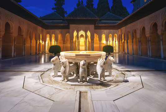 Illuminated Court of the Lions (Patio de los Leones) with fountain at Nasrid Palaces of Alhambra at night - Granada, Andalusia, Spain