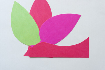 three paper shapes (green, red, and pink) on blank paper