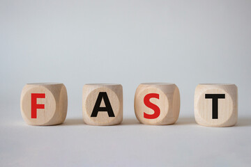 Fast symbol. Concept word Fast on wooden cubes. Beautiful white background. Business and Fast concept. Copy space.