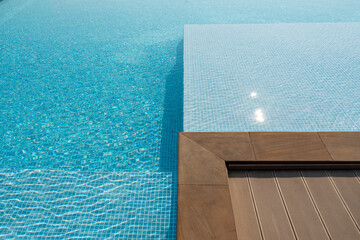 The corner of a swimming pool on a sunny day.