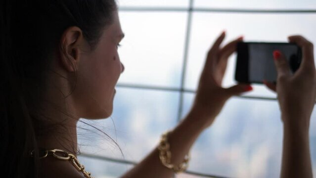 Woman taking pictures from Bangkok skyline