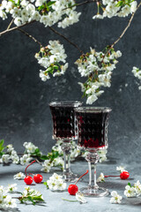 Cherry liqueur in a glass and fresh fruit with fresh berries and blossoms, Berry alcoholic drinks concept