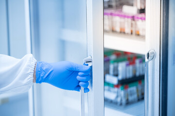 Close up scientist hand wear blue gloves opening storage reagent container for laboratory...