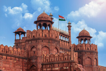 Red Fort or Lal Qila in Delhi with indian flag on foreground with moody sk.UNESCO World heritage site. Discover the India. Open world after covid-19 - 614226221
