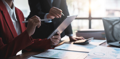 Group of business people working together on new project with planning analytical report at...